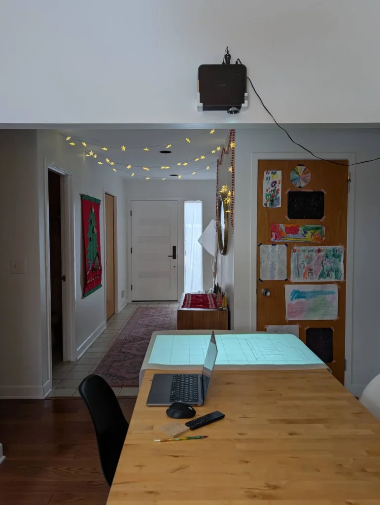 Ceiling mounted projector setup projecting a sewing pattern onto a work table.